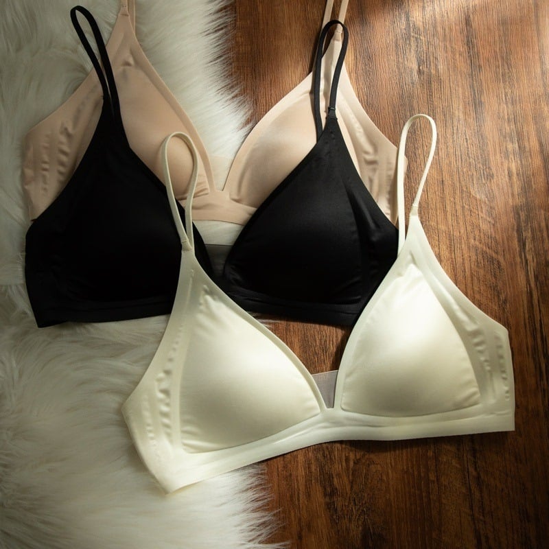 Bevielė trikampio formos liemenėlė iš pieno satino nailono, gilus V formos iškirptė, plonos petnešėlės, be siūlių, plonas formuojamas kaušelis