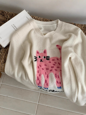 Sieviešu vilnas džemperis ar apļveida kaklu un laimīgās kaķes izšuvumu karikatūru stilā (Zīmols: Yi rong; Sezona: Ziemas 2025; Audums: Vilna; Galvenā sastāvdaļa: Vilna 95%+; Otrā sastāvdaļa: Vilna 90-95%)