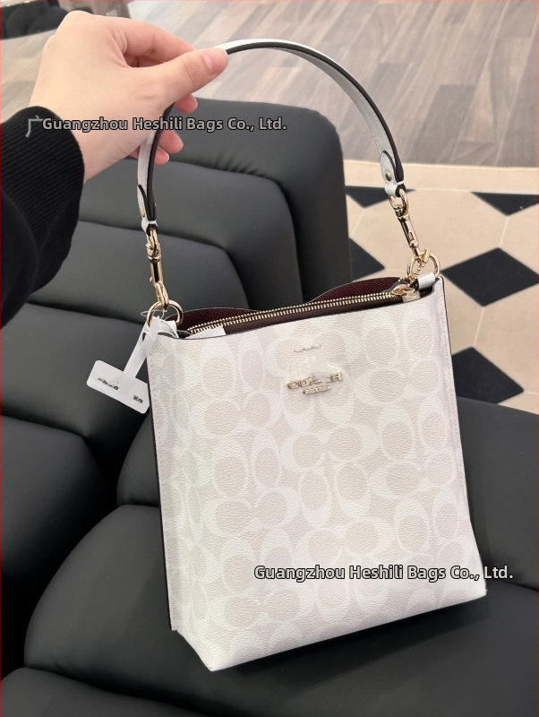 Mollie taška typu vedro z pravej kože; vertikálny štvorcový tvar; magnetické zapínanie; vnútorné vrecká: vrecko na telefón a laminované zipsové vrecko; dvojité remene