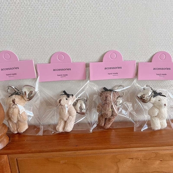 Plüss medve kulcstartó szív alakú medállal – rajzfilmszerű stílus, táskára akasztható dísz; anyag: textil; minta: medve; 2024 nyári kiadás; feldolgozás: félig manuális.