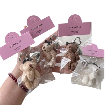 Plüss medve kulcstartó szív alakú medállal – rajzfilmszerű stílus, táskára akasztható dísz; anyag: textil; minta: medve; 2024 nyári kiadás; feldolgozás: félig manuális.