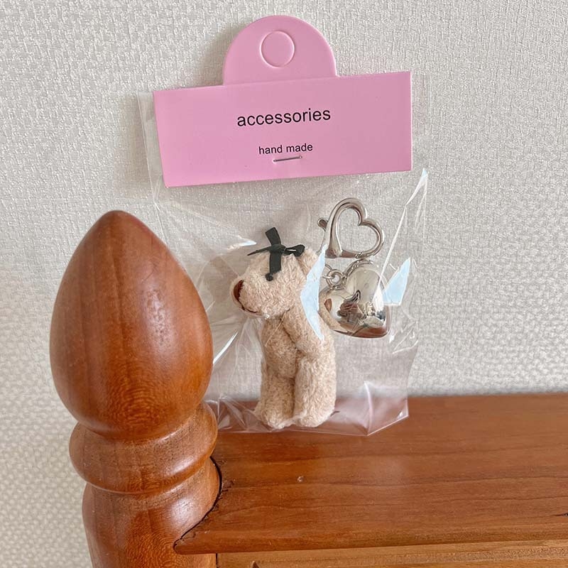 Plüss medve kulcstartó szív alakú medállal – rajzfilmszerű stílus, táskára akasztható dísz; anyag: textil; minta: medve; 2024 nyári kiadás; feldolgozás: félig manuális.