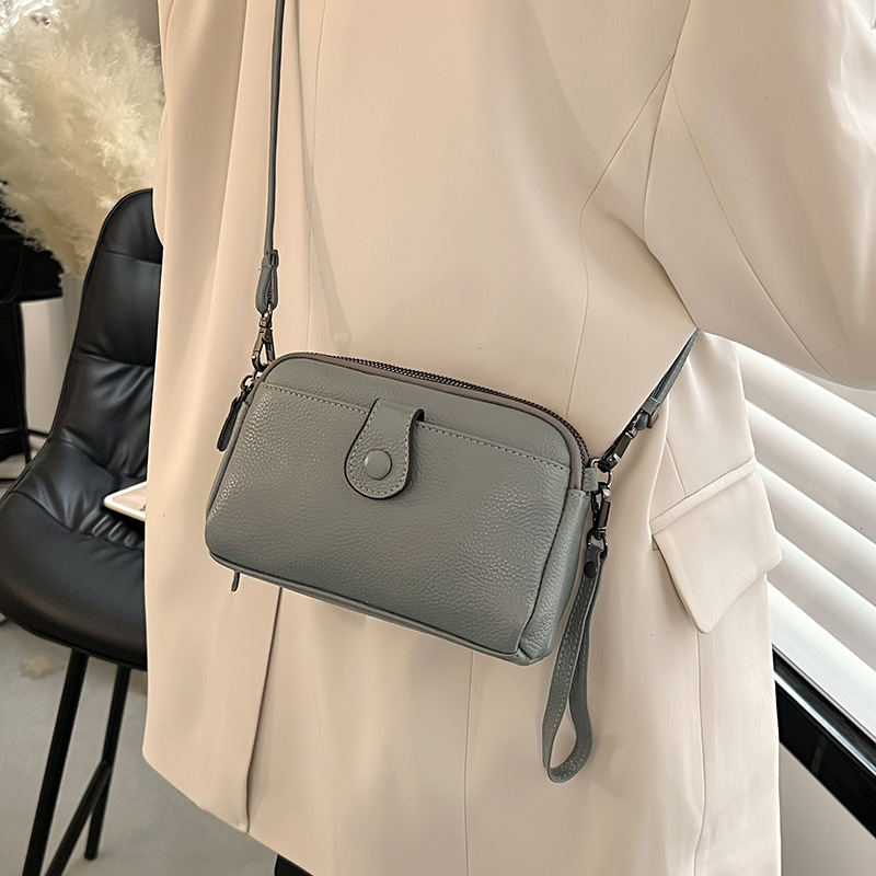 Valódi bőr női kézitáska, első réteg marhabőrből, kagyló alakú test, keresztpántos vállon, cipzáras nyitás, poliészter bélés