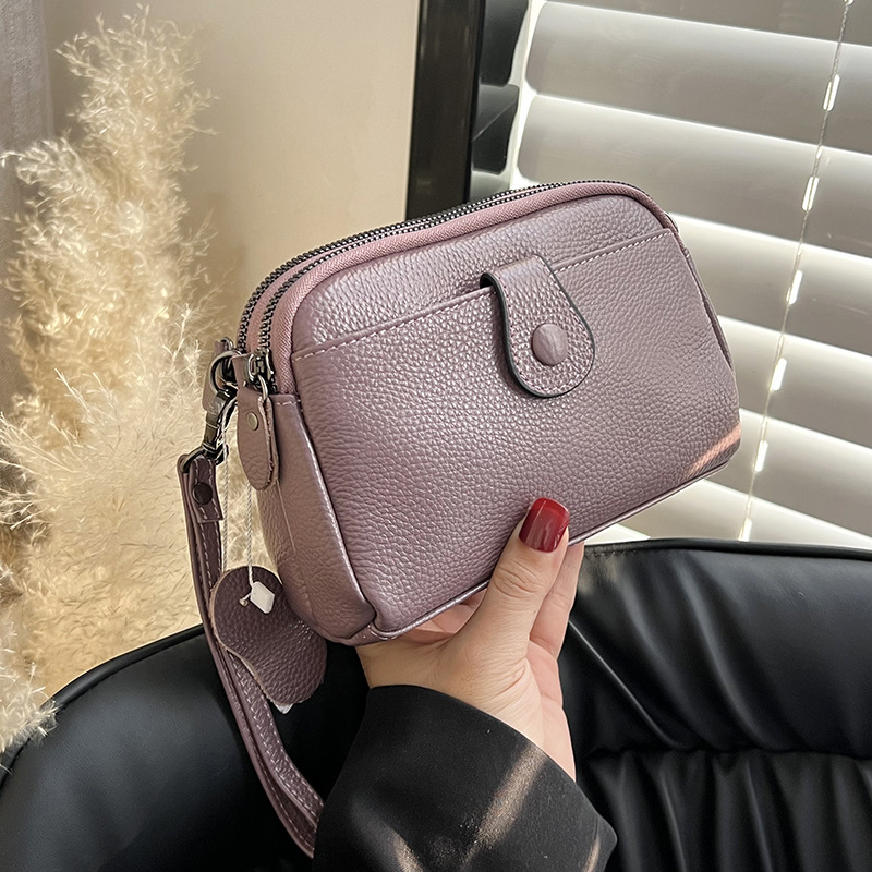 Valódi bőr női kézitáska, első réteg marhabőrből, kagyló alakú test, keresztpántos vállon, cipzáras nyitás, poliészter bélés