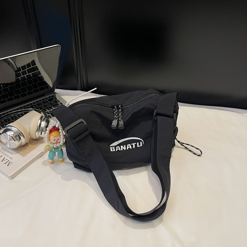 Női crossbody táska utcai stílusban, vízszintes négyszögletes forma, vászon anyag, cipzáras zárás.