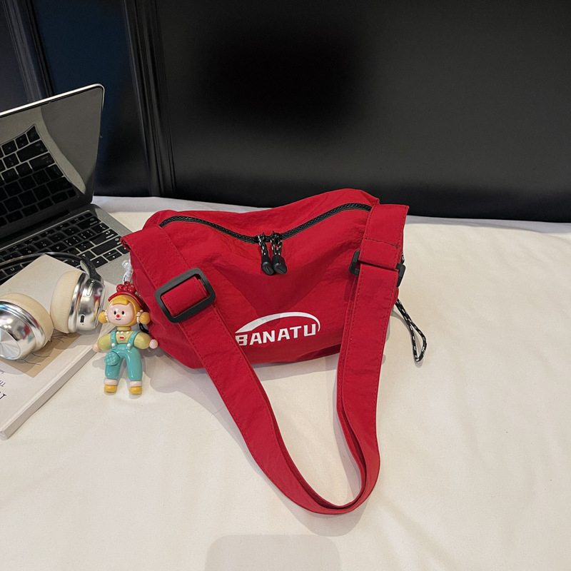 Női crossbody táska utcai stílusban, vízszintes négyszögletes forma, vászon anyag, cipzáras zárás.