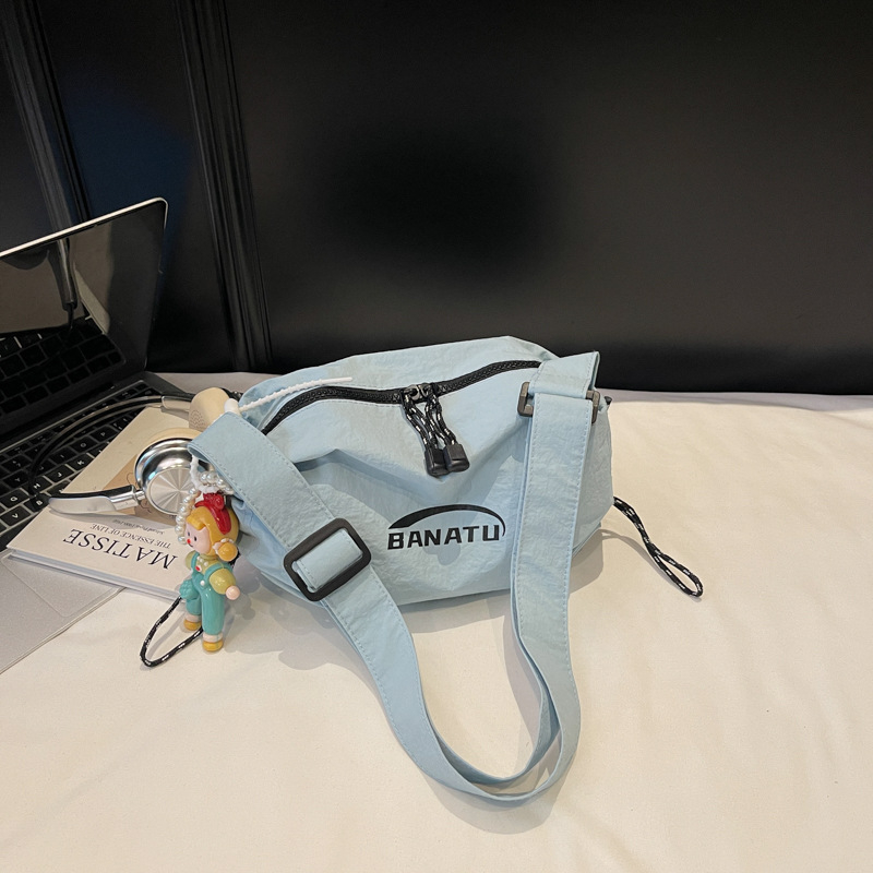 Női crossbody táska utcai stílusban, vízszintes négyszögletes forma, vászon anyag, cipzáras zárás.