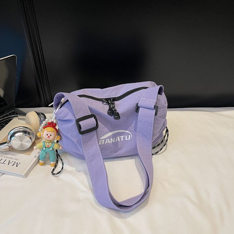 Női crossbody táska utcai stílusban, vízszintes négyszögletes forma, vászon anyag, cipzáras zárás.
