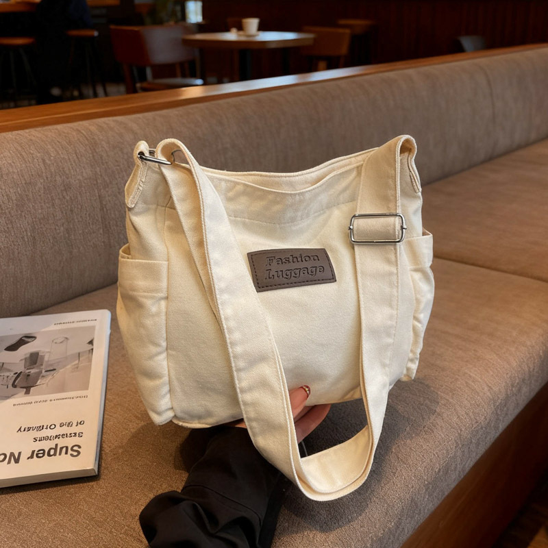 Crossbody torba od platna, horizontalni kvadratni oblik, zatvaranje na zip, unutarnja pretinica za mobitel, jedna naramenica