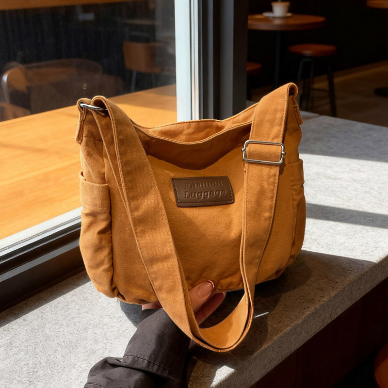 Crossbody torba od platna, horizontalni kvadratni oblik, zatvaranje na zip, unutarnja pretinica za mobitel, jedna naramenica