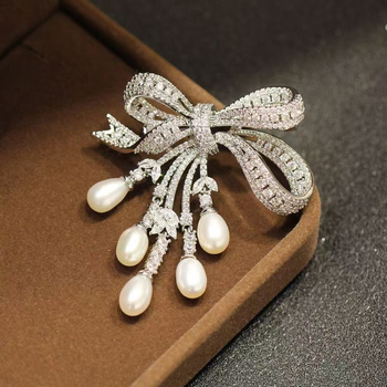 Brošňa s perlou a strapcami v tvare mašle, zliatina, elektroplatovanie, dámsky doplnok, leto 2025