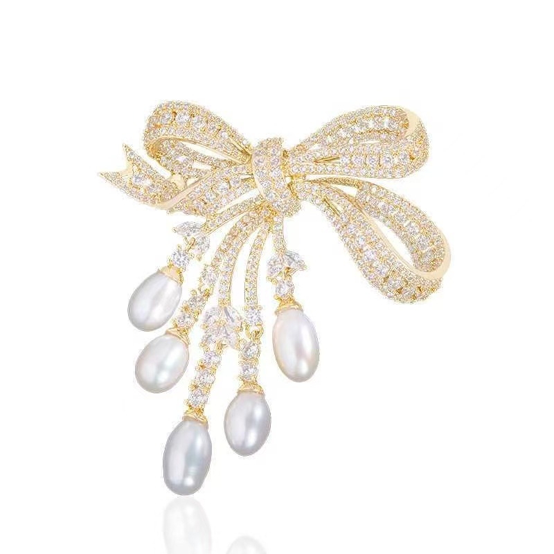 Brošňa s perlou a strapcami v tvare mašle, zliatina, elektroplatovanie, dámsky doplnok, leto 2025