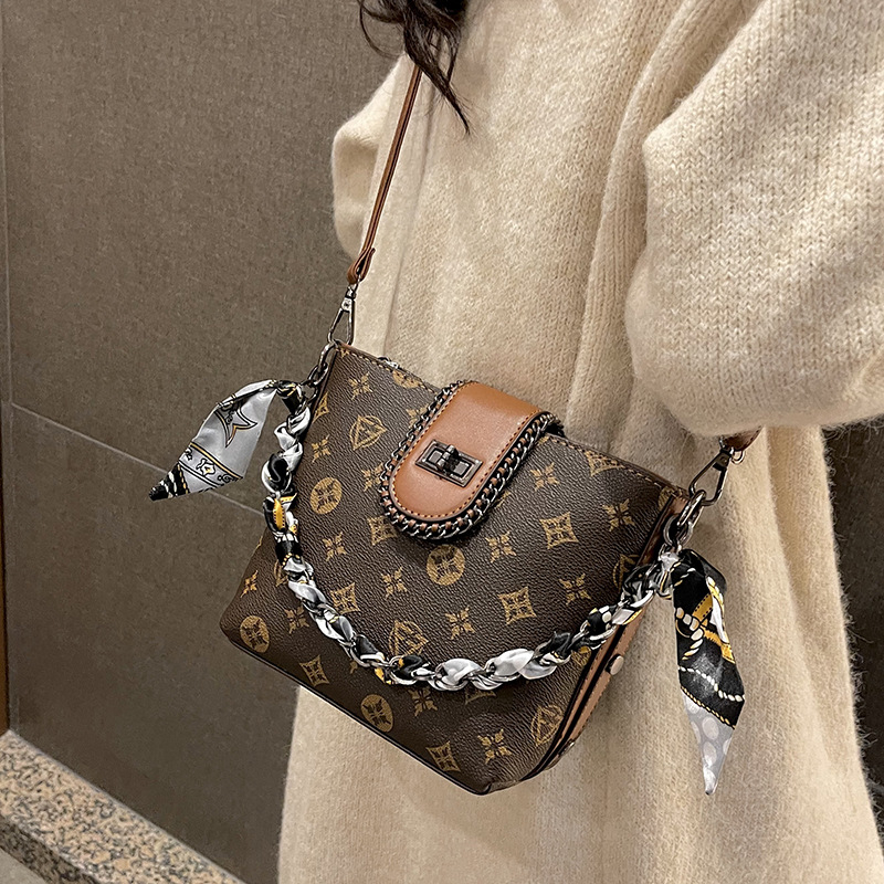 Geantă bucket din PU, formă verticală pătrată, închidere cu fermoar, căptușeală din poliester, o singură curea de umăr.