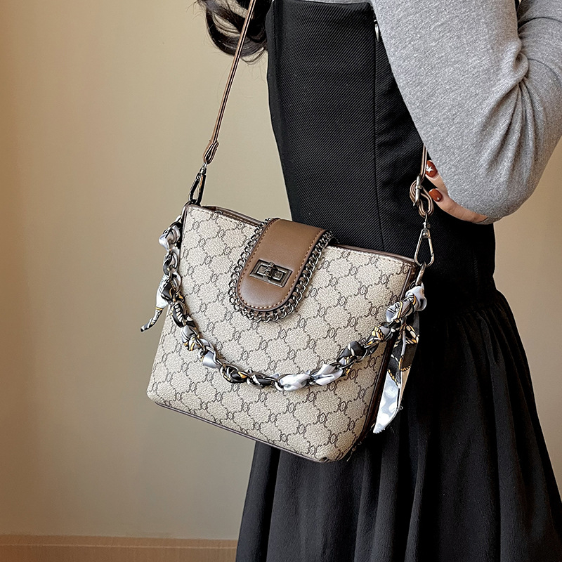 Geantă bucket din PU, formă verticală pătrată, închidere cu fermoar, căptușeală din poliester, o singură curea de umăr.