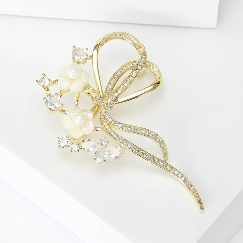 Brooch kagylóvirág motívummal, elektroplattált; formák: korona, virág, masni, levél; uniszex divatkiegészítő