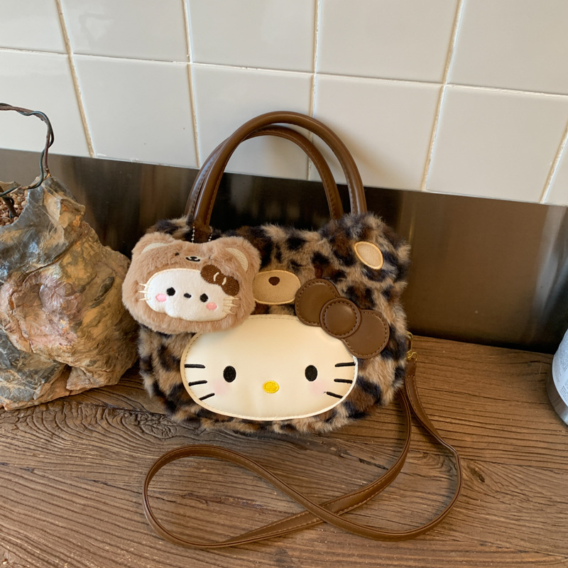 Gyerekeknek szánt rajzfilmszerű oldaltáska macska motívummal (Nylon; kerek forma; cipzáras záródás; belső cipzáros rekesz; egyoldali vállpánt)