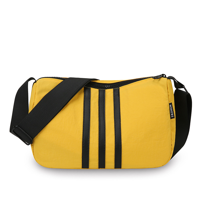 Nylonová taška cez rameno, horizontálny štvorcový tvar, zapínanie na zips, vnútorná kapsa na zips a kapsa na dokumenty, jeden popruh, mestská jednoduchosť.