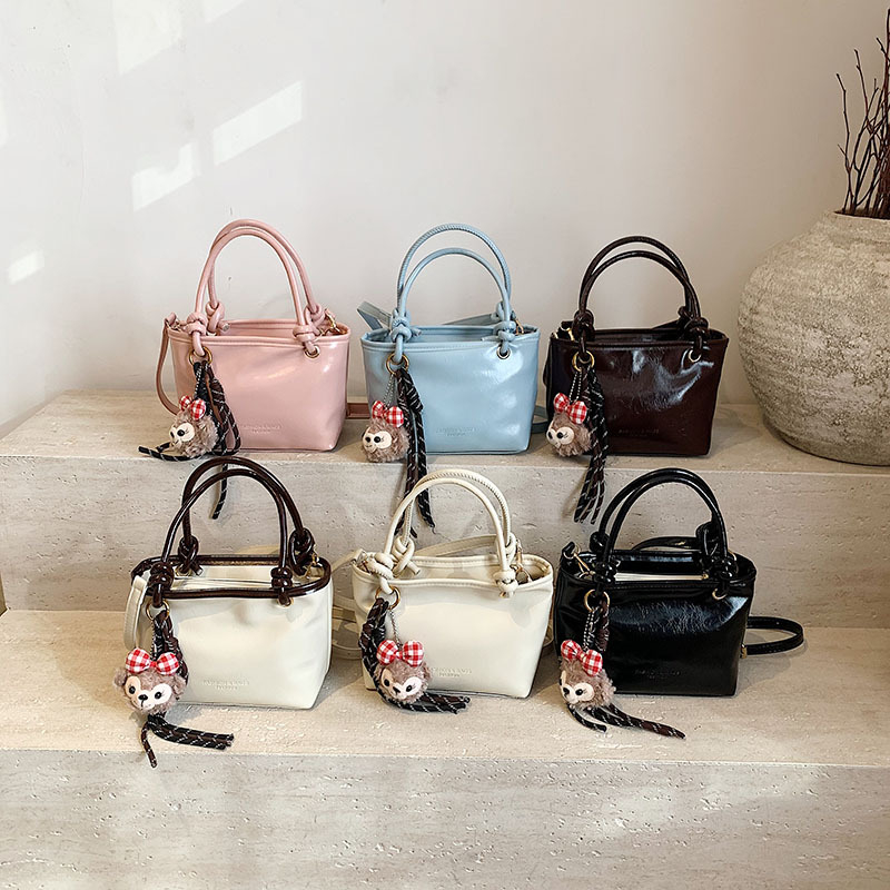 2025 proljeće: teksturirana retro jednobojna bucket torba preko ramena, minimalistički stil