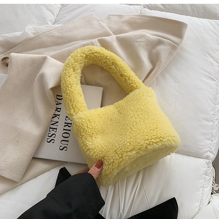 Plišana bucket bag, cilindričnog oblika, srednje veličine, magnetno zatvaranje, podstava od sintetičke kože, gradski minimalistički stil.