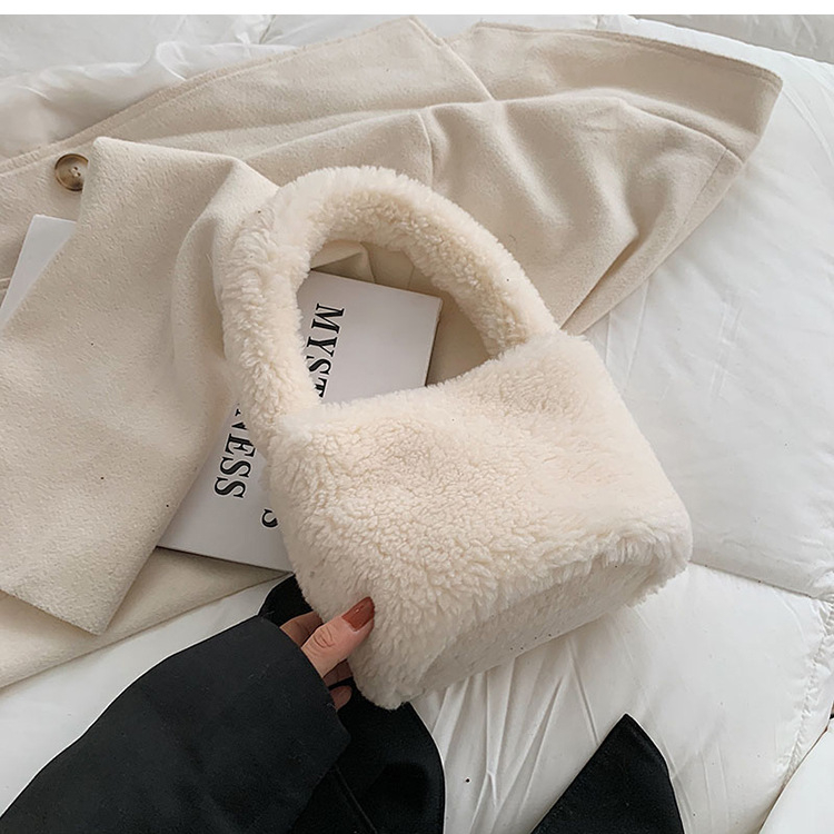 Plišana bucket bag, cilindričnog oblika, srednje veličine, magnetno zatvaranje, podstava od sintetičke kože, gradski minimalistički stil.