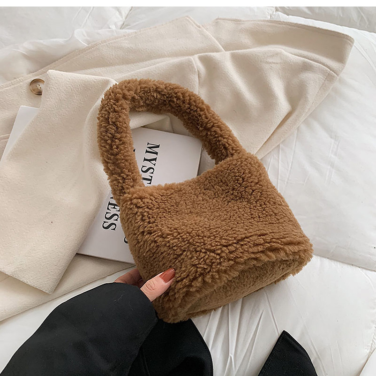 Plišana bucket bag, cilindričnog oblika, srednje veličine, magnetno zatvaranje, podstava od sintetičke kože, gradski minimalistički stil.