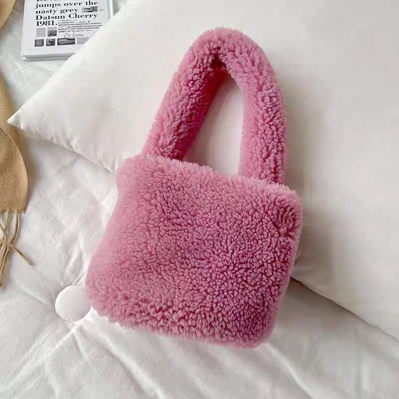 Plišana bucket bag, cilindričnog oblika, srednje veličine, magnetno zatvaranje, podstava od sintetičke kože, gradski minimalistički stil.