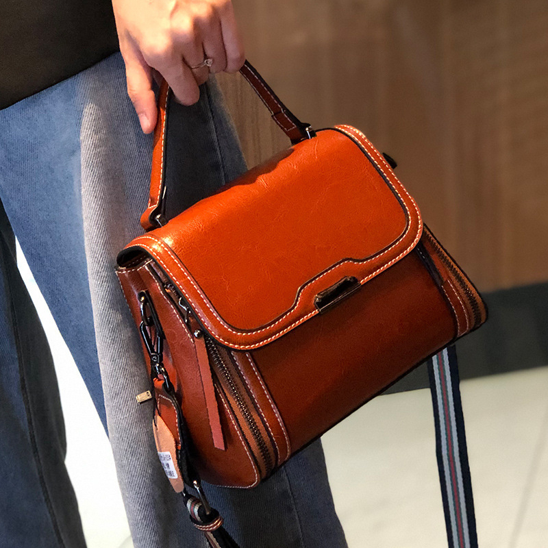 Ženska crossbody torbica od prave kože, koža s uljno-voskastim završetkom, uspravni kvadratni oblik, zatvaranje poklopac, unutarnji džepovi s patentnim zatvaračem te pretinci za mobitel i osobnu iskaznicu