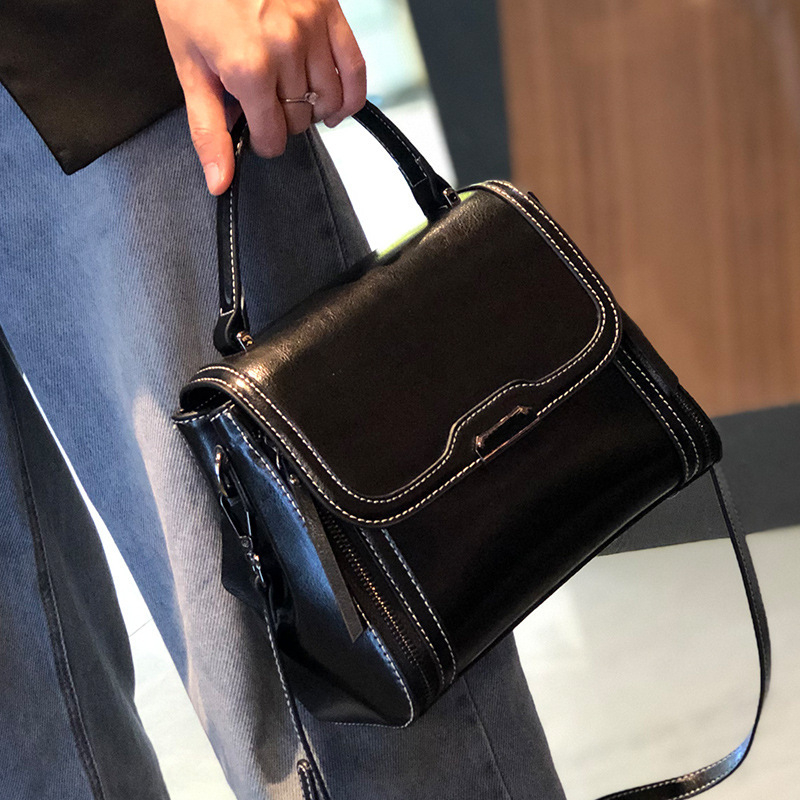 Ženska crossbody torbica od prave kože, koža s uljno-voskastim završetkom, uspravni kvadratni oblik, zatvaranje poklopac, unutarnji džepovi s patentnim zatvaračem te pretinci za mobitel i osobnu iskaznicu