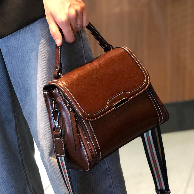 Ženska crossbody torbica od prave kože, koža s uljno-voskastim završetkom, uspravni kvadratni oblik, zatvaranje poklopac, unutarnji džepovi s patentnim zatvaračem te pretinci za mobitel i osobnu iskaznicu