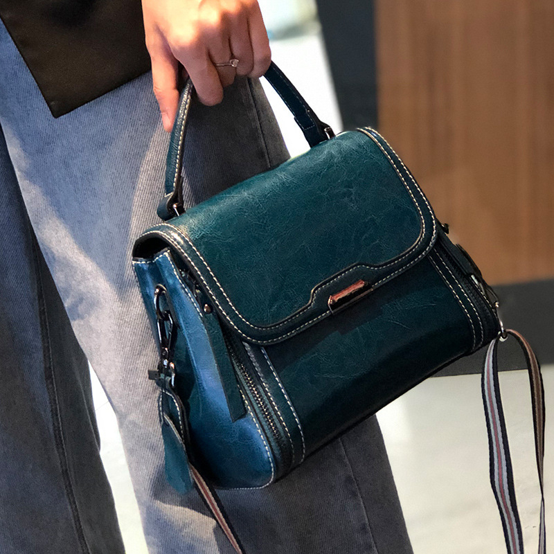 Ženska crossbody torbica od prave kože, koža s uljno-voskastim završetkom, uspravni kvadratni oblik, zatvaranje poklopac, unutarnji džepovi s patentnim zatvaračem te pretinci za mobitel i osobnu iskaznicu