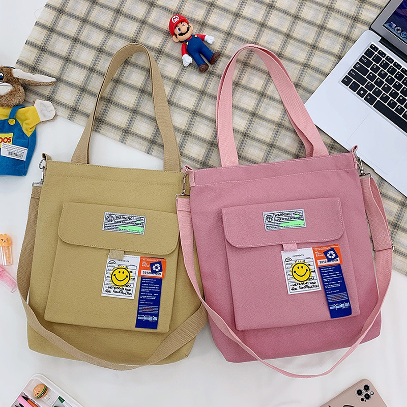 Torba preko ramena od platna, gradski minimalistički stil, uspravni kvadratni oblik, zatvarač, unutarnje pretinice za laptop, karticu/ID, pretinica sa zatvaranjem