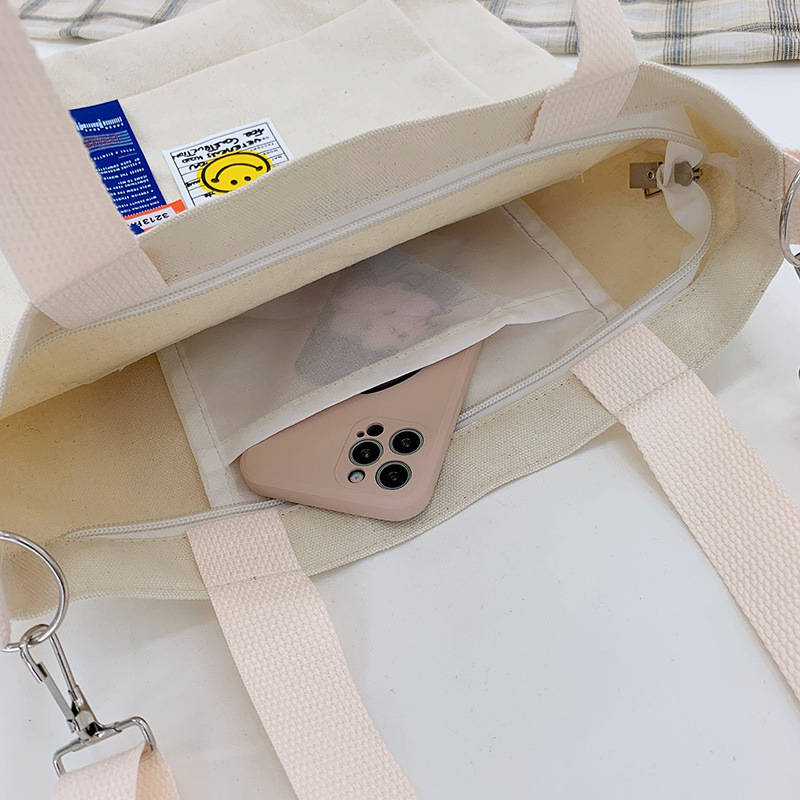 Torba preko ramena od platna, gradski minimalistički stil, uspravni kvadratni oblik, zatvarač, unutarnje pretinice za laptop, karticu/ID, pretinica sa zatvaranjem
