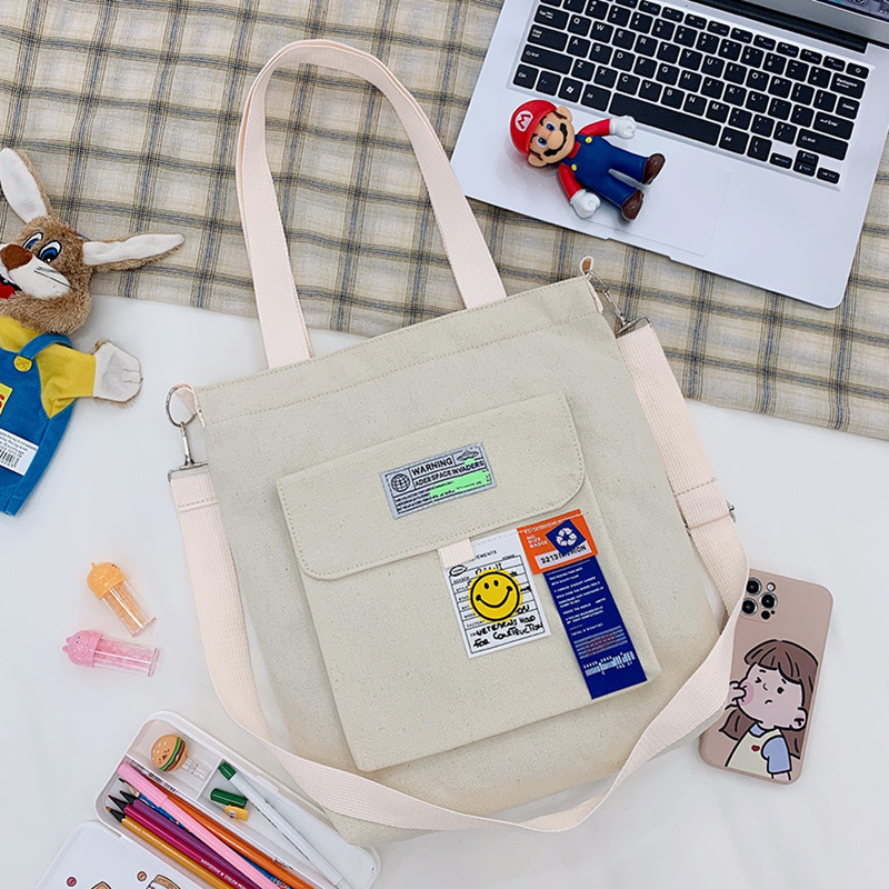 Torba preko ramena od platna, gradski minimalistički stil, uspravni kvadratni oblik, zatvarač, unutarnje pretinice za laptop, karticu/ID, pretinica sa zatvaranjem