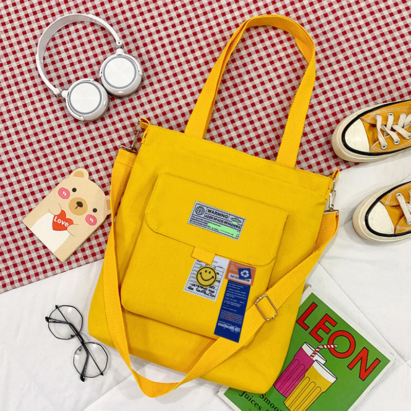Torba preko ramena od platna, gradski minimalistički stil, uspravni kvadratni oblik, zatvarač, unutarnje pretinice za laptop, karticu/ID, pretinica sa zatvaranjem