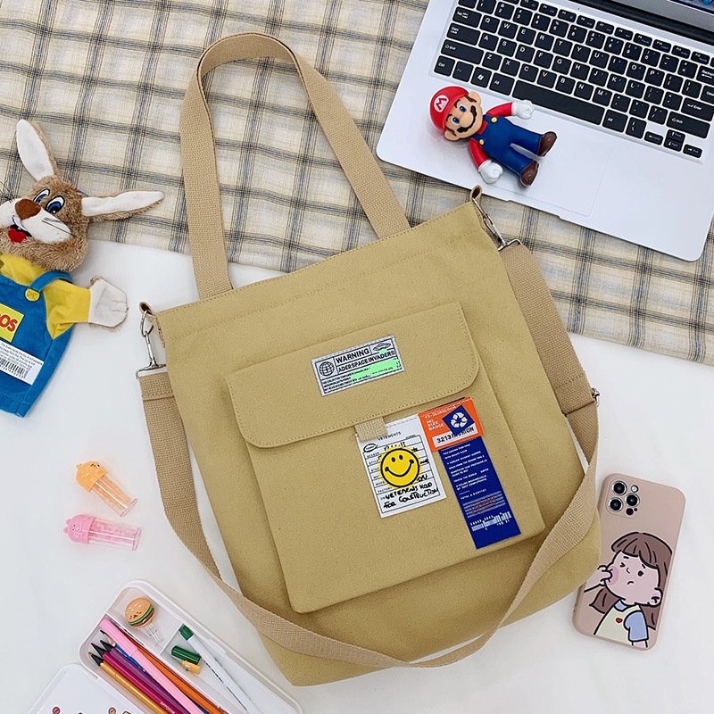 Torba preko ramena od platna, gradski minimalistički stil, uspravni kvadratni oblik, zatvarač, unutarnje pretinice za laptop, karticu/ID, pretinica sa zatvaranjem