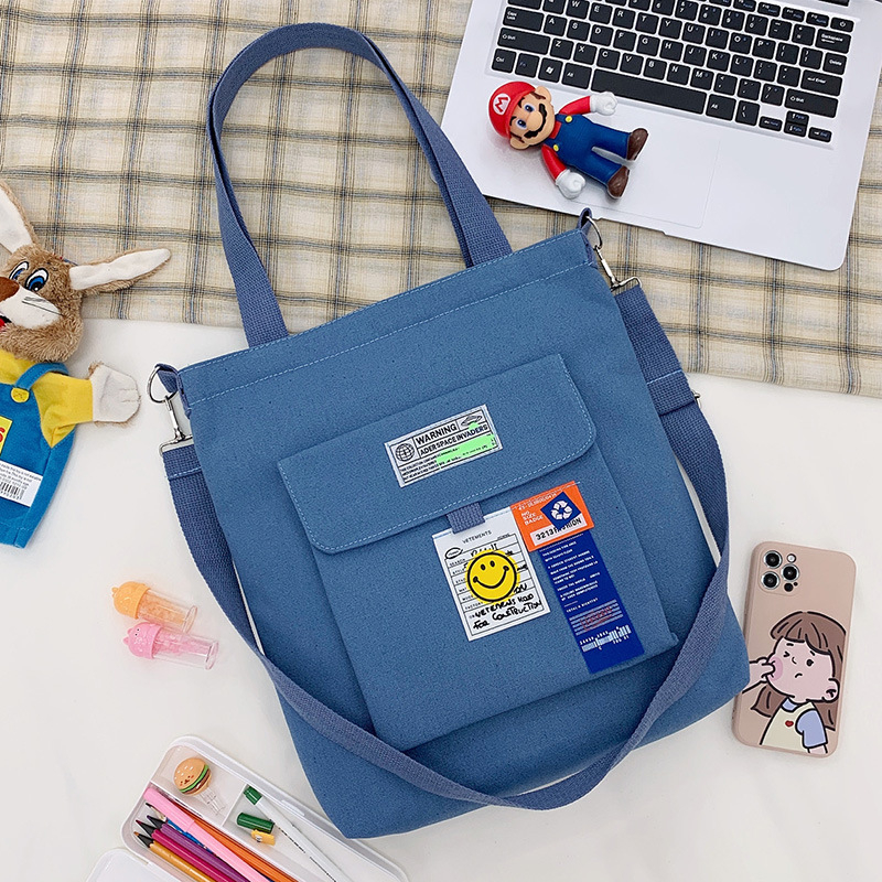 Torba preko ramena od platna, gradski minimalistički stil, uspravni kvadratni oblik, zatvarač, unutarnje pretinice za laptop, karticu/ID, pretinica sa zatvaranjem