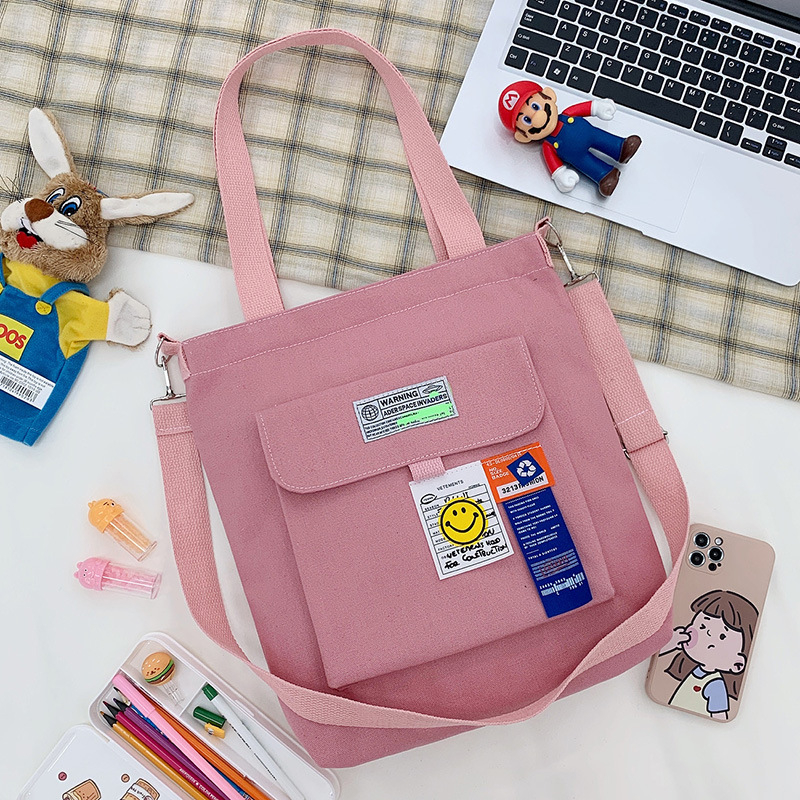 Torba preko ramena od platna, gradski minimalistički stil, uspravni kvadratni oblik, zatvarač, unutarnje pretinice za laptop, karticu/ID, pretinica sa zatvaranjem