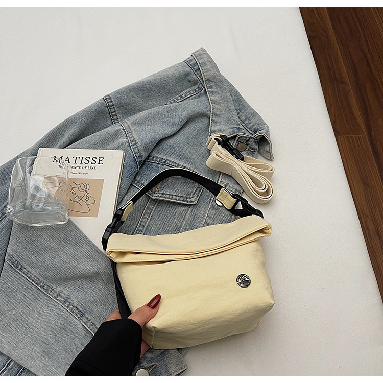 Ženska crossbody bucket torbica — gradski minimalistički stil, tekstilni materijal, zatvaranje zipom, poliester podstava, unutarnji džepovi: džep na zatvarač, džep za telefon, džep za dokumente (Jesen 2025)
