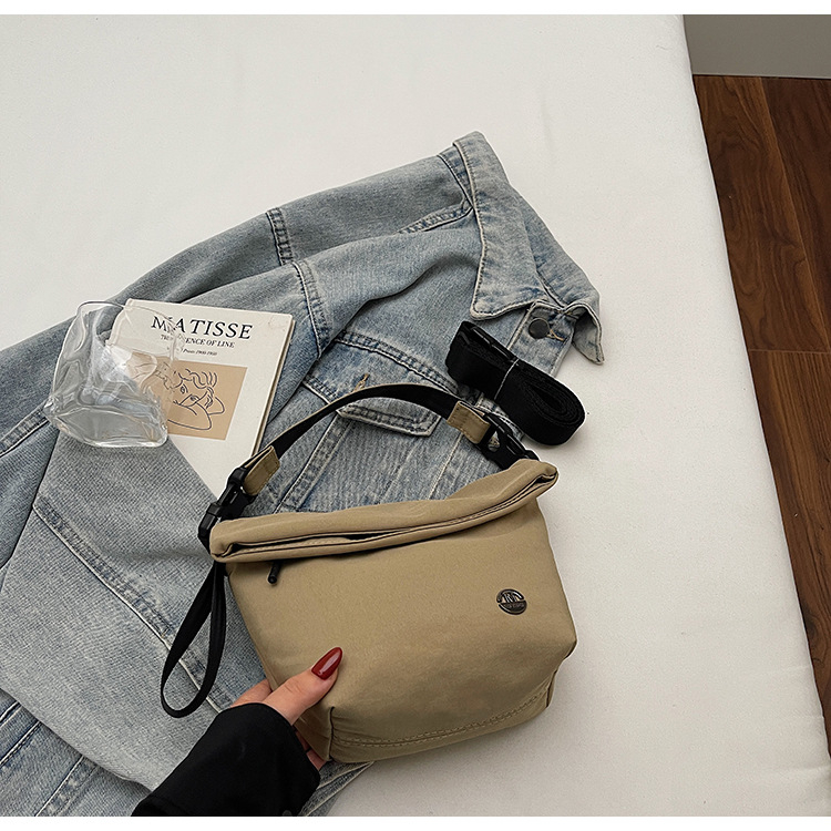 Ženska crossbody bucket torbica — gradski minimalistički stil, tekstilni materijal, zatvaranje zipom, poliester podstava, unutarnji džepovi: džep na zatvarač, džep za telefon, džep za dokumente (Jesen 2025)