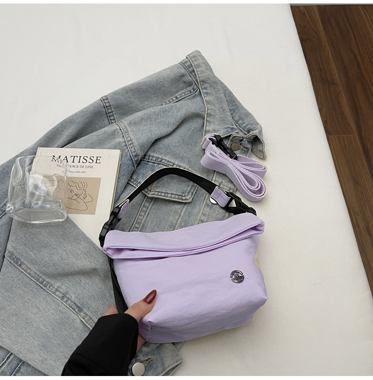 Ženska crossbody bucket torbica — gradski minimalistički stil, tekstilni materijal, zatvaranje zipom, poliester podstava, unutarnji džepovi: džep na zatvarač, džep za telefon, džep za dokumente (Jesen 2025)