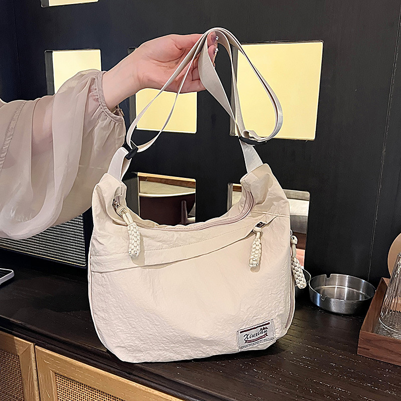 Nylon dumpling alakú crossbody táska, cipzárral, telefontartó zsebbel, poliészter bélés, egyetlen vállpánt