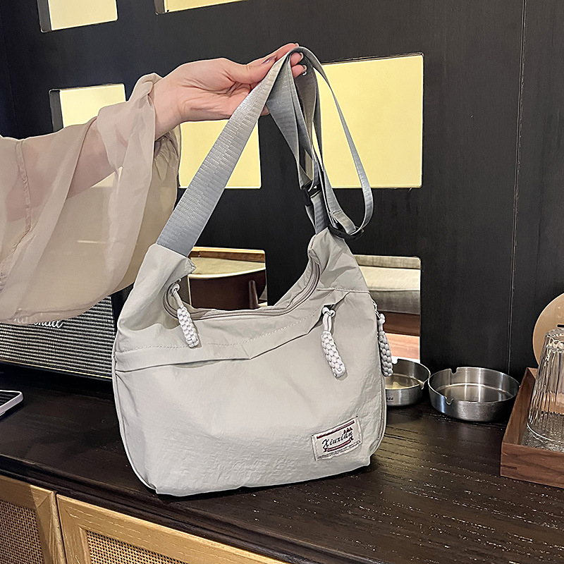 Nylon dumpling alakú crossbody táska, cipzárral, telefontartó zsebbel, poliészter bélés, egyetlen vállpánt