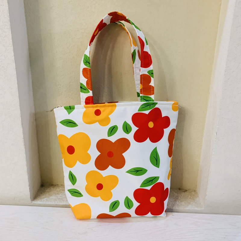 Virágos mintás kézitáska cipzárral, kompozit anyagból, bélés vászon, függőleges négyzetes formájú, belső zsebek telefon és személyazonosító igazolvány számára