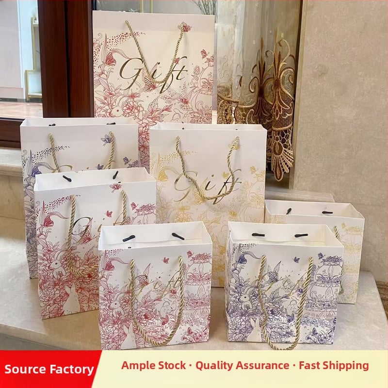 Dovanų maišelis iš balto kartono, rankų piešimo stilius, prekinis ženklas Comilia, spaudos technika, logotipo spausdinimas galimas