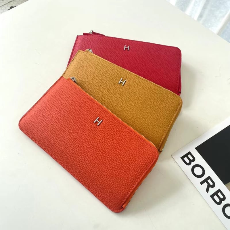 Dámska peňaženka z pravej kože s zrnitou textúrou, na zips, horizontálne štvorcový tvar, viaceré priehradky na karty a vrecká na mobilný telefón a dokumenty.