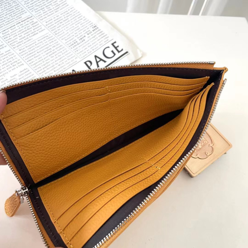 Dámska peňaženka z pravej kože s zrnitou textúrou, na zips, horizontálne štvorcový tvar, viaceré priehradky na karty a vrecká na mobilný telefón a dokumenty.