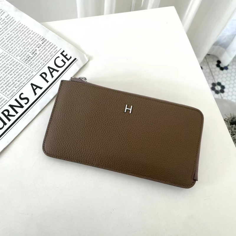 Dámska peňaženka z pravej kože s zrnitou textúrou, na zips, horizontálne štvorcový tvar, viaceré priehradky na karty a vrecká na mobilný telefón a dokumenty.