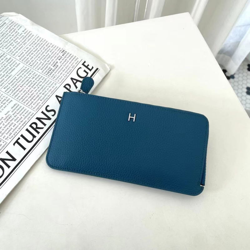 Dámska peňaženka z pravej kože s zrnitou textúrou, na zips, horizontálne štvorcový tvar, viaceré priehradky na karty a vrecká na mobilný telefón a dokumenty.