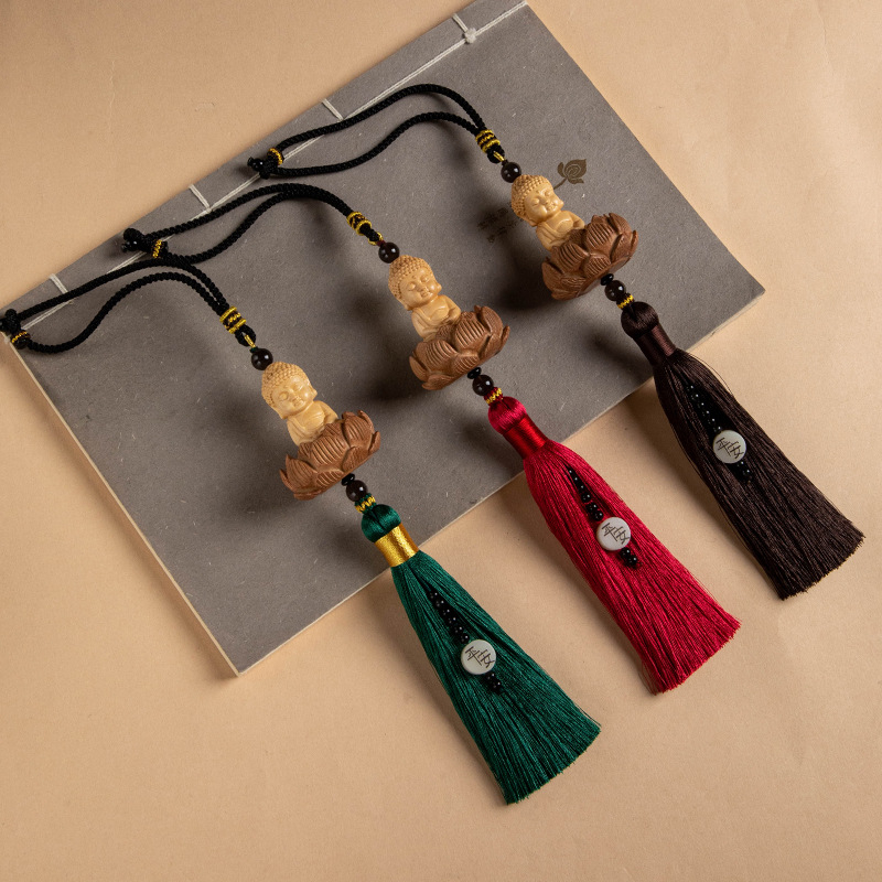 Pandantiv auto din lemn cu Buddha mic, bază de lotus și ciucuri lungi; decor interior modern.