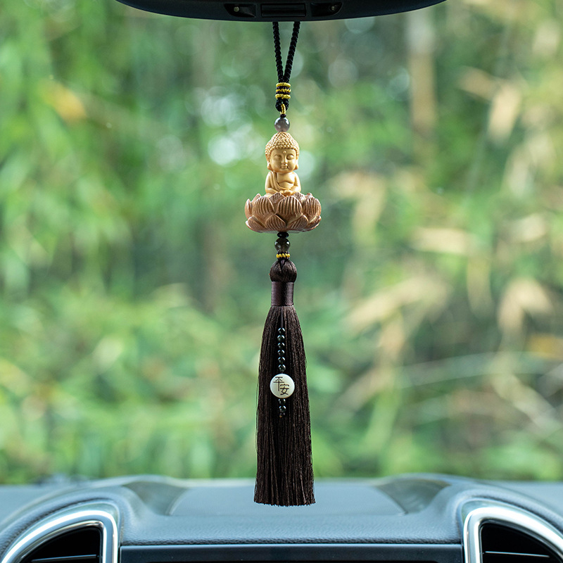 Pandantiv auto din lemn cu Buddha mic, bază de lotus și ciucuri lungi; decor interior modern.